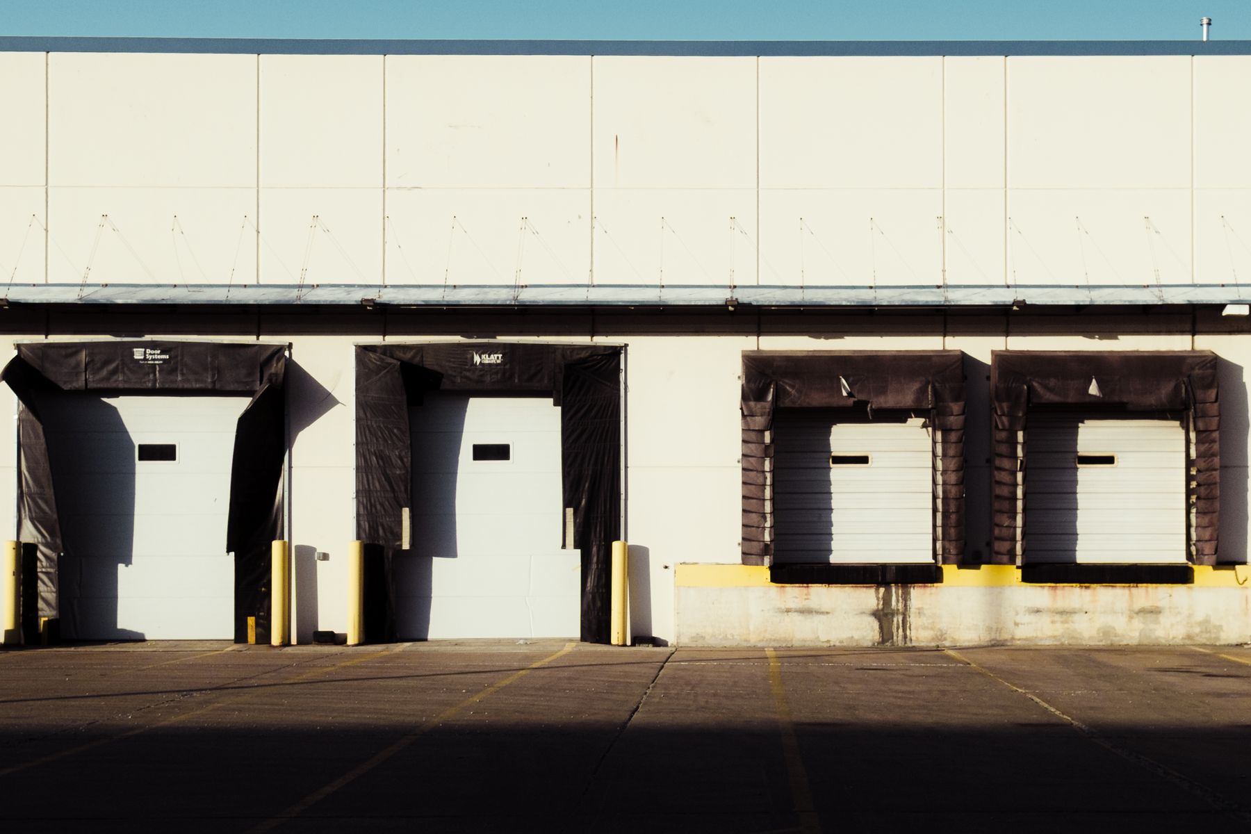 Sunlit industrial loading dock with a row of closed bay doors